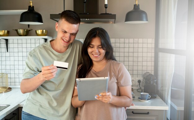 Uomo e donna che utilizzano tablet per lo shopping online con carta di credito