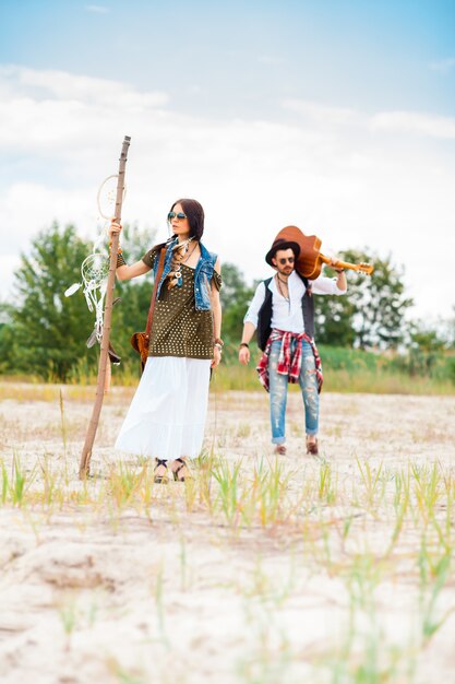 Uomo e donna come pantaloni a vita bassa di boho contro cielo blu