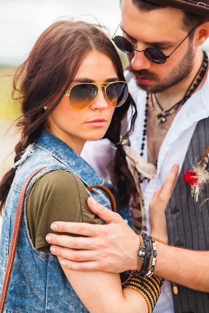 Uomo e donna come pantaloni a vita bassa di boho contro cielo blu