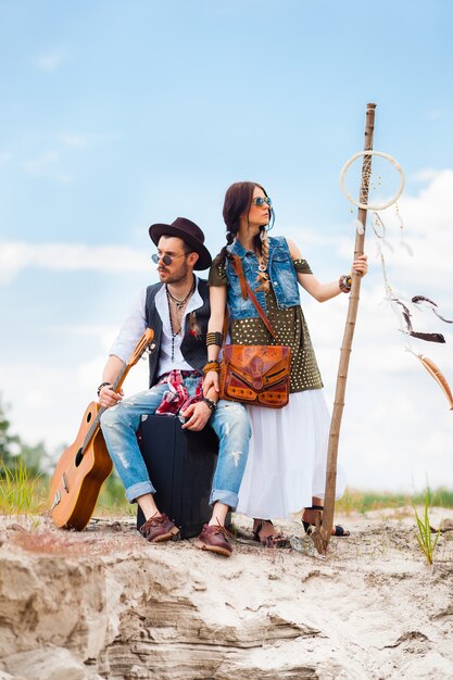 Uomo e donna come pantaloni a vita bassa di boho contro cielo blu