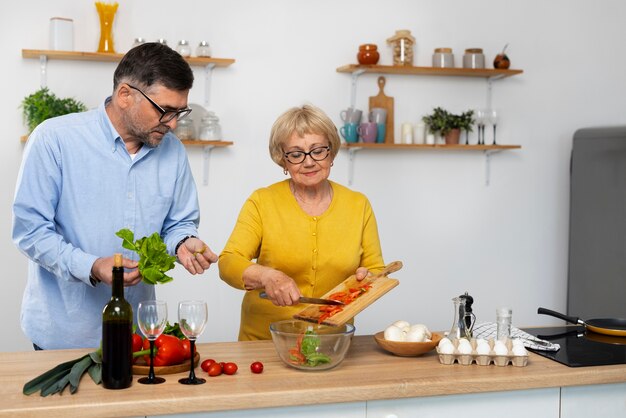 Uomo e donna del piano medio che cucinano in cucina