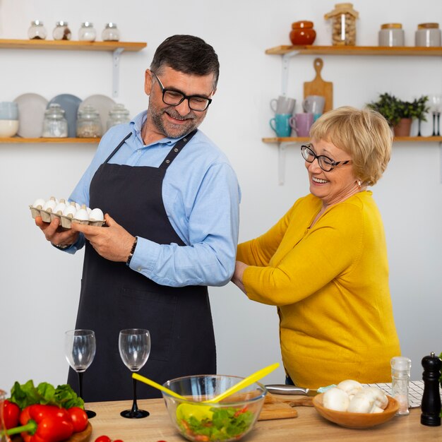 Uomo e donna del piano medio che cucinano in cucina