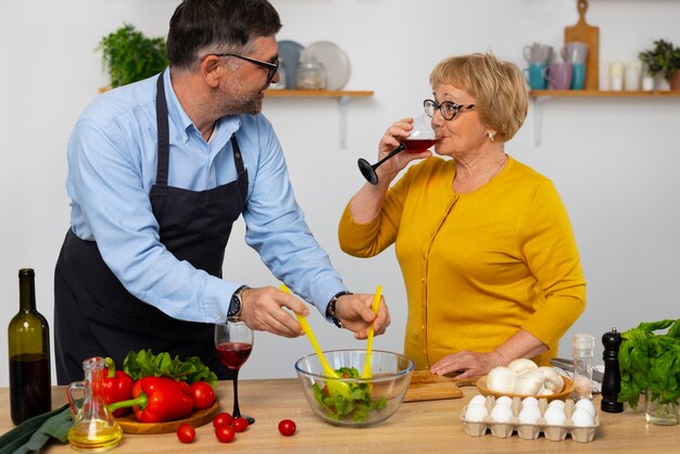 Uomo e donna del piano medio che cucinano in cucina