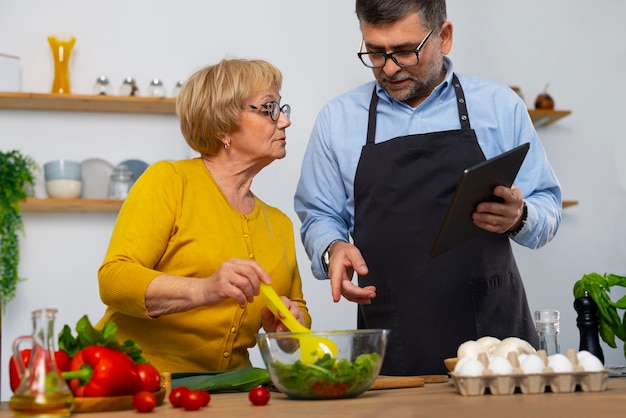 Uomo e donna del piano medio che cucinano in cucina