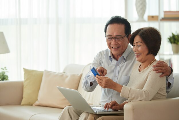 Uomo e donna di mezza età che fanno spesa online