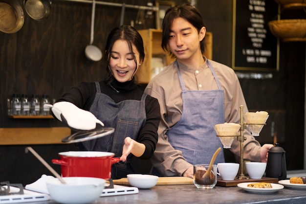 Uomo e donna giapponesi che cucinano in un ristorante