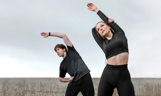 Uomo e donna in abiti sportivi che esercitano all'aperto