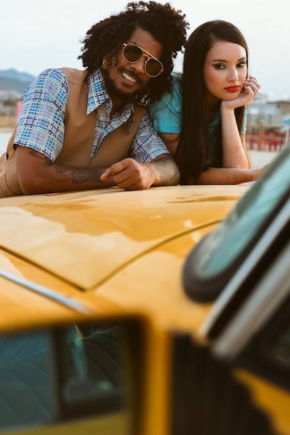 Uomo e donna in posa in stile retrò con auto