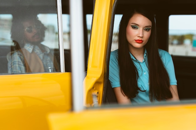 Uomo e donna in posa in stile retrò con auto