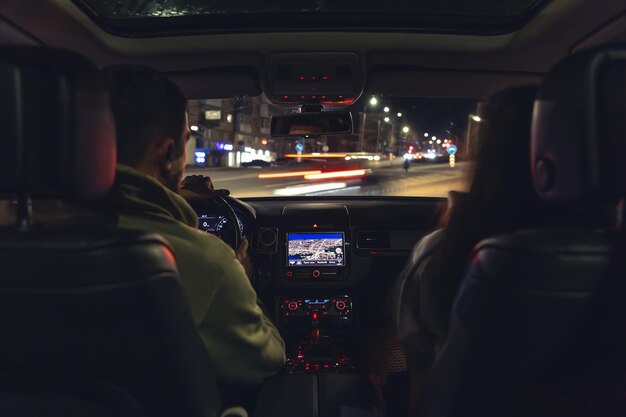 Uomo e donna in un'auto di notte vista dall'auto