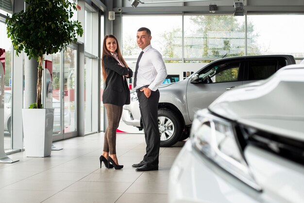 Uomo e donna insieme al concessionario auto