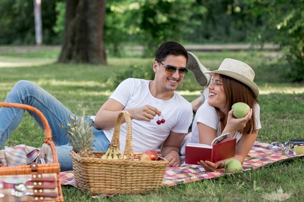 Uomo e donna mangiando frutta mentre sorridendo