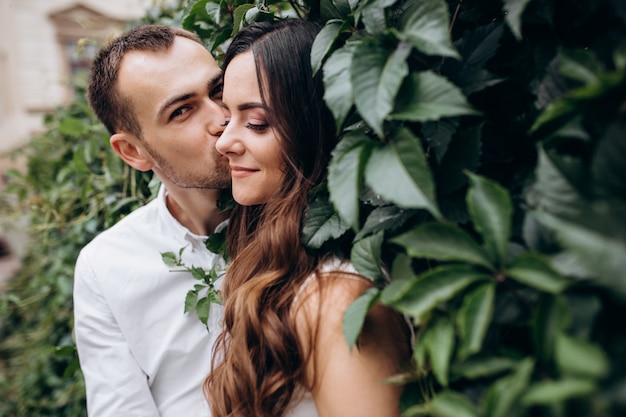 uomo e donna si baciano tenendosi in piedi sulla strada nel giorno del loro matrimonio