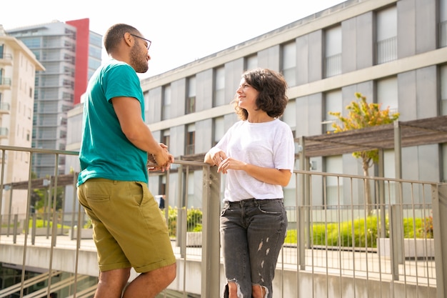 Uomo e donna sorridenti che parlano sulla via