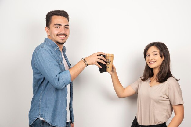 Uomo e donna sorridenti con tazze di caffè.