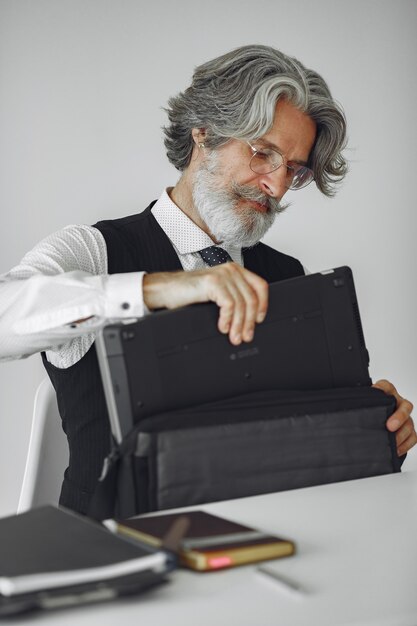 Uomo elegante in ufficio. Uomo d'affari in camicia bianca. L'uomo lavora con il laptop.