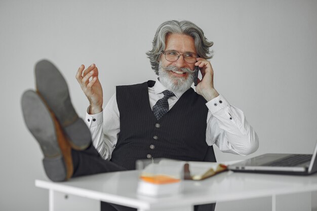 Uomo elegante in ufficio. Uomo d'affari in camicia bianca. L'uomo lavora con il telefono.