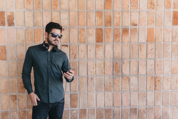 Uomo elegante usando telefono e auricolari