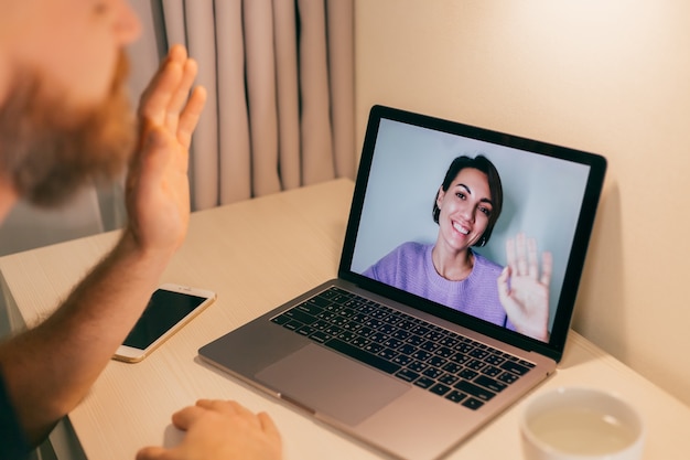 Uomo facetime a casa, chiamando la sua amica moglie fidanzata dal laptop in camera da letto.