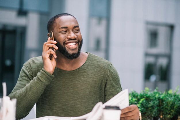 Uomo felice che parla sul telefono nella caffetteria