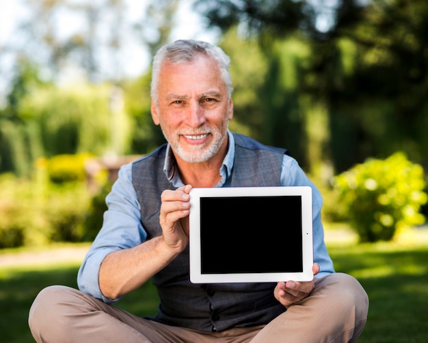 Uomo felice che tiene un modello di tablet