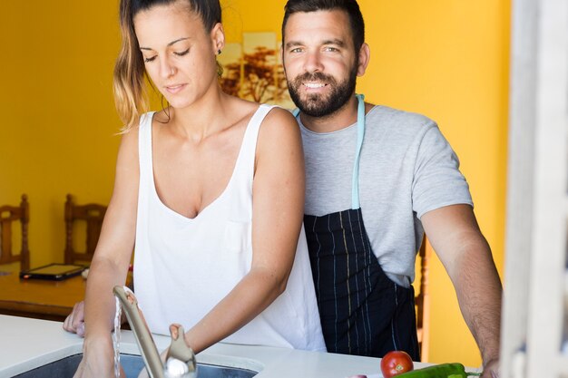 Uomo felice con sua moglie in piedi in cucina