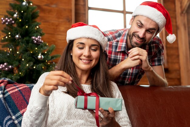 Uomo felice del colpo medio che offre a sua moglie un regalo