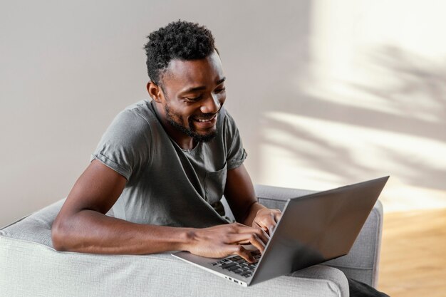 Uomo felice del colpo medio con il computer portatile