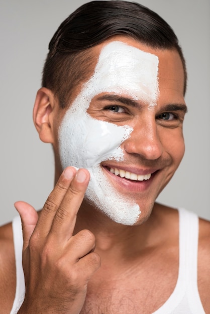 Uomo felice del primo piano che applica la maschera per il viso