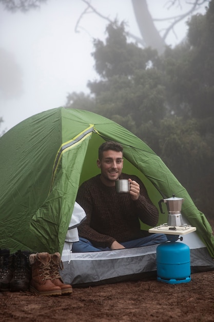 Uomo felice della foto a figura intera in tenda