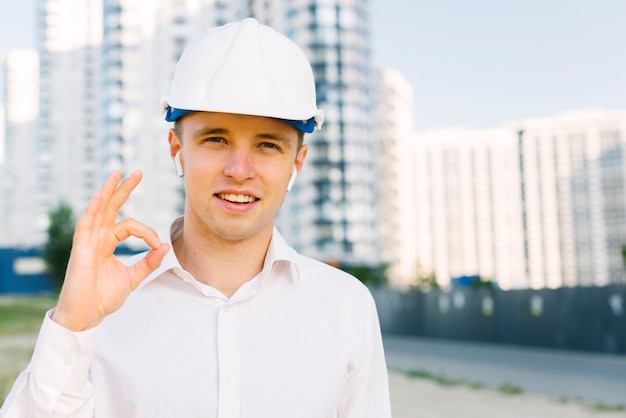 Uomo felice di vista frontale con il casco che mostra approvazione