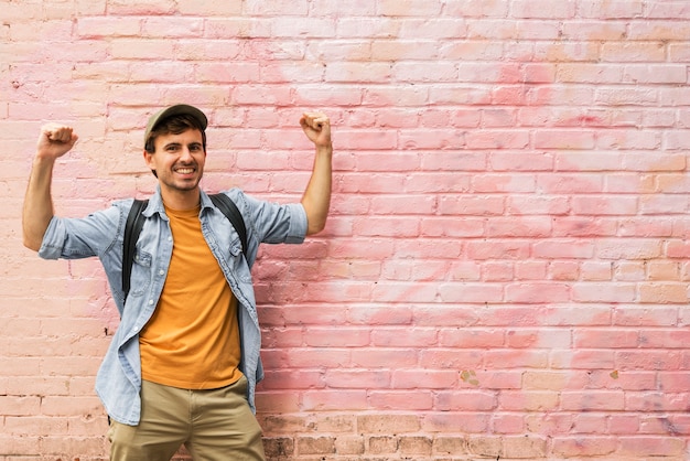 Uomo felice in città con parete rosa