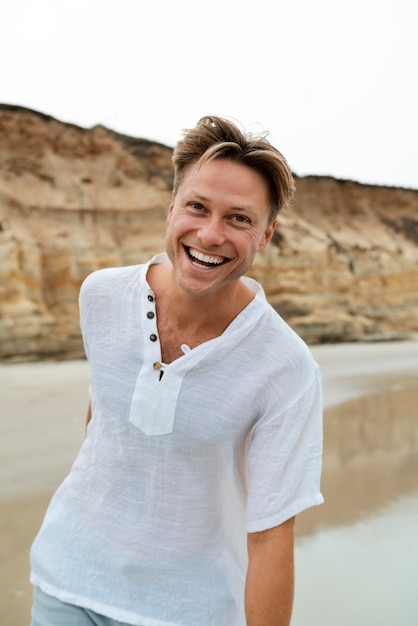 Uomo felice in spiaggia, colpo medio