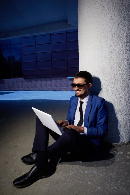 Uomo felice lavorando con il suo computer portatile