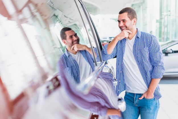 Uomo felice nel concessionario auto