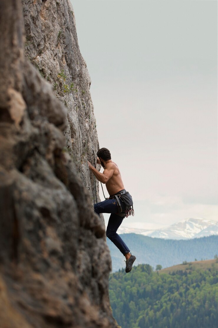 Foto gratuito uomo forte che si arrampica su una montagna