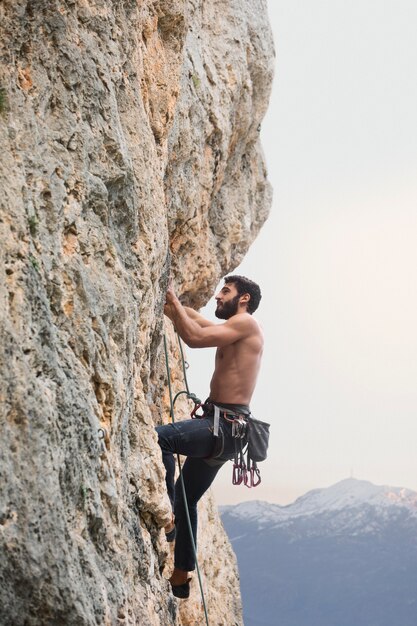 Uomo forte che si arrampica su una montagna