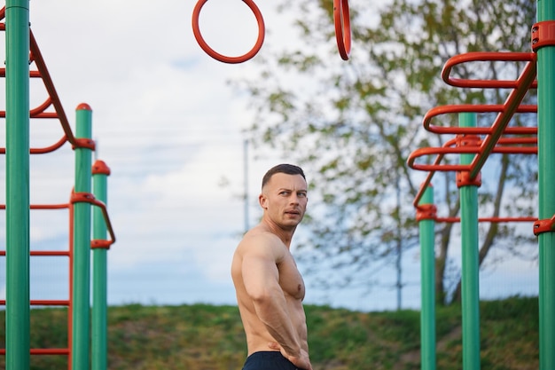 Uomo forte e sano che riposa dopo l'allenamento sul campo sportivo