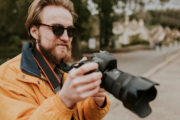 Uomo fotografo che guarda le sue foto sulla fotocamera