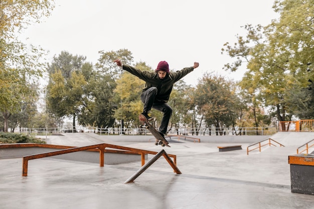 Uomo fuori con lo skateboard nel parco