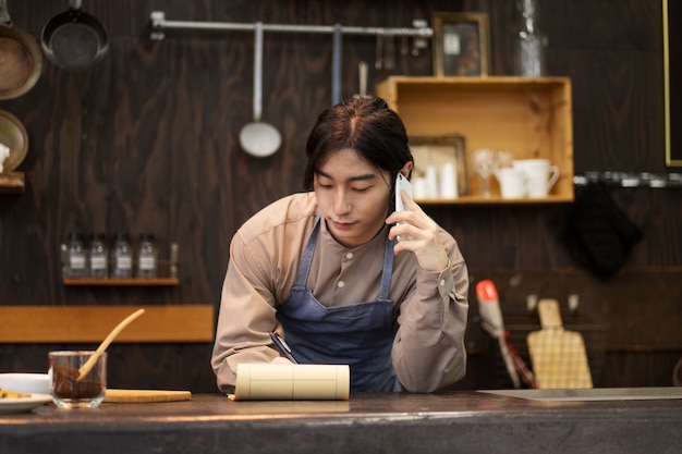 Uomo giapponese che parla su smartphone in un ristorante
