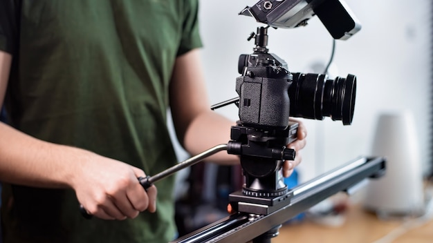 Uomo giovane creatore di contenuti le riprese con la fotocamera sul dispositivo di scorrimento, rig professionale