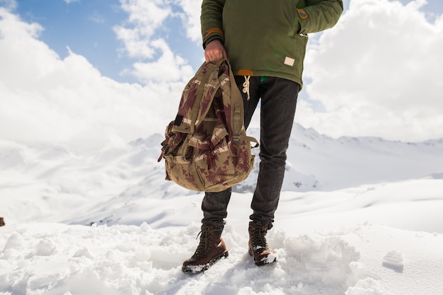 Uomo giovane hipster, escursioni in montagna, vacanze invernali in viaggio