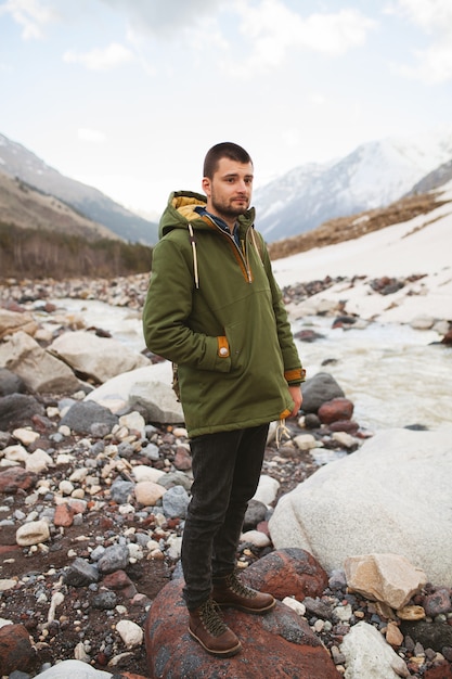 Uomo giovane hipster, escursioni in riva al fiume, natura selvaggia, vacanze invernali