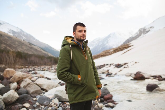 Uomo giovane hipster, escursioni in riva al fiume, natura selvaggia, vacanze invernali