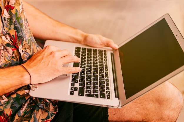 Uomo in abiti casual che lavora al computer portatile