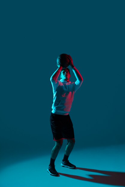 Uomo in abiti sportivi giocando a basket con luci fresche