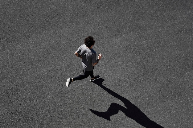 Uomo in abiti sportivi in esecuzione su strada