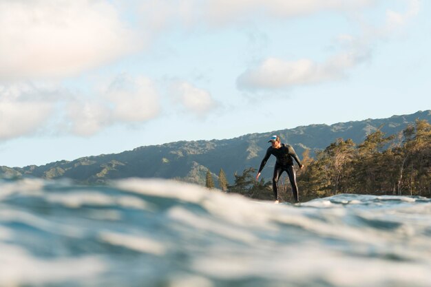 Uomo in attrezzatura speciale che fa surf alle hawaii