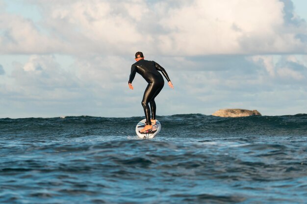 Uomo in attrezzatura speciale che fa surf alle hawaii